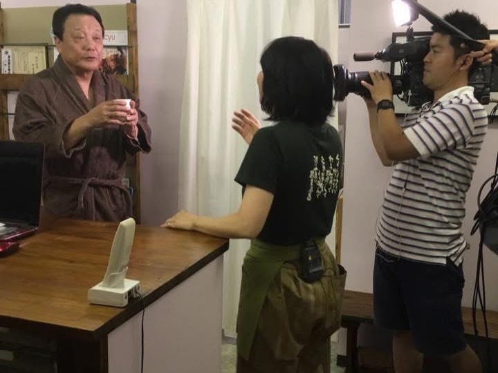 テレビ取材で白湯を手にする池谷公二郎さん